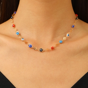 Gros plan détaillé d'un collier en chaîne dorée avec des perles œil grec sur un mannequin