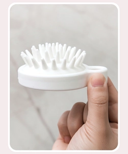 Side view of white silicone scalp massager brush with finger grip and soft bristles