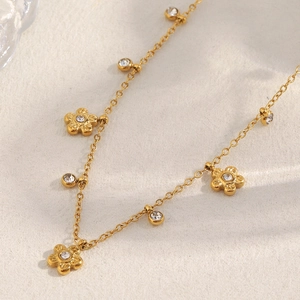 Macro view of gold-plated flower necklace with circular crystal pendant details