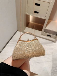 Sparkling gold shell-shaped evening clutch with crystal crown clasp and metal handle