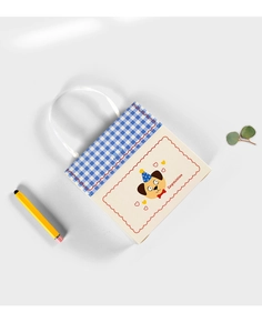 Close-up of cream gift bag with blue gingham flap and cute puppy illustration