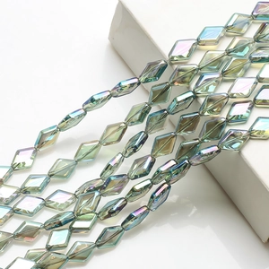 Close-up of diamond-shaped crystal glass beads with iridescent green and purple coating