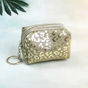Macro detail of champagne gold leopard print mini pouch with silver zipper and keychain