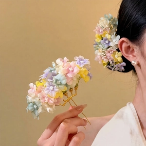 Close-up of elegant fabric flower hair comb with colorful macaron petals and gold metal teeth