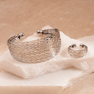 Silver wavy multi-layer textured open bangle and ring set on stone pedestal