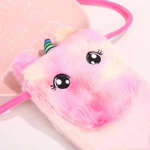Close-up of plush unicorn bag with pink yellow gradient fur and embroidery details