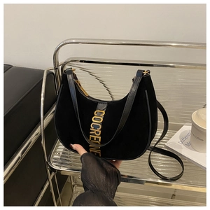 Detail of black suede hobo bag featuring premium golden COCRENE metal hardware decoration