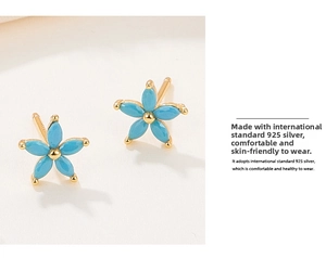 Macro detail of 925 sterling silver flower earrings with turquoise blue petals