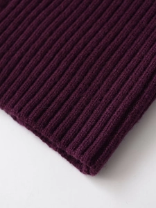 Gros plan sur la maille côtelée violet foncé montrant les détails des fibres douces