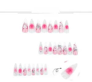 Detail view of 3D stiletto press-on nails with metal bows, pearls and heart patterns