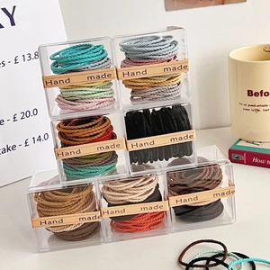 Macro shot of colorful twisted hair ties in a transparent box with Hand Made label