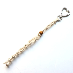 Detail of bohemian handmade macrame bag charm with cotton rope and heart metal clasp