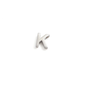 Detailed view of silver stainless steel letter K charm with a smooth metallic finish