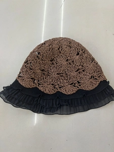 Detailed top view of handmade hollow crochet sun hat with brown knit and black tiered lace
