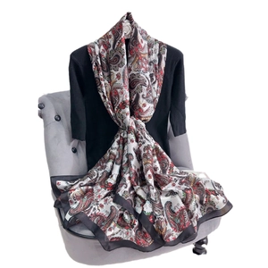 Floral paisley printed large silk scarf in red and brown draped over a chair
