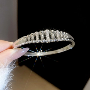Macro detail of silver plated wave bracelet with sparkling zircon inlay on wrist