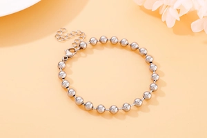 Detailed macro view of silver beaded titanium bracelet with lobster clasp and extender chain