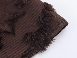 Makroaufnahme von dunkelbraunem Jacquard-Stoff mit feinen Fransen an der Kante