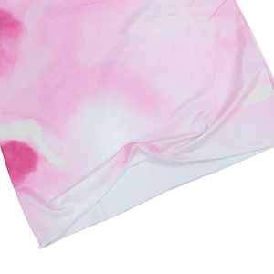 Détail du tissu tie-dye rose et blanc avec texture lisse et ourlet cousu en surjet