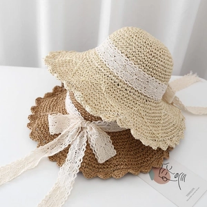 Women's wide brim straw sun hat with elegant lace ribbon bow in beige and brown colors