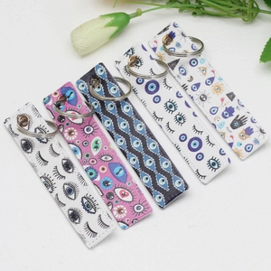 Close-up of five colorful Evil Eye pattern PU leather keychains with silver metal rings