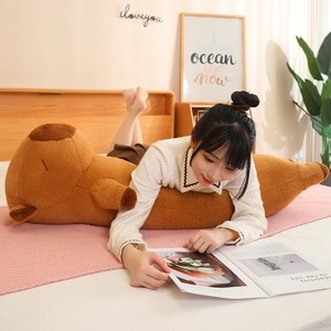 Cozy scene of a woman leaning on a long brown capybara plush body pillow at home