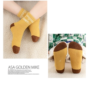 Detail of warm ginger yellow terry socks with 'ROAR' print and brown heel patches