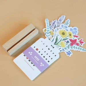 Detail of 2025 bloomy flowers desk calendar with artistic wood base and July floral card