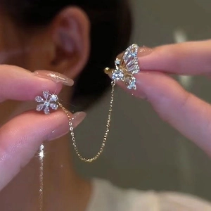 Close-up of gold butterfly flower ear cuff with sparkling zircon tassels on a model