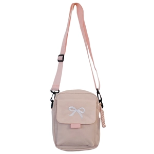 Close-up of pink crossbody bag with white bow embroidery and adjustable shoulder strap