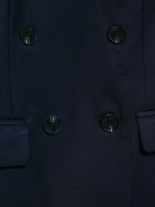Macro shot of navy blue twill fabric suit featuring dark marble pattern buttons