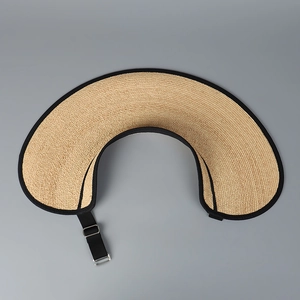 Detail of raffia sun hat texture showing woven straw material and black fabric edge