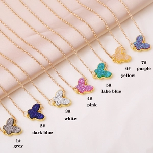 Detailed grid of seven colorful butterfly pendants with golden chains in various vibrant shades