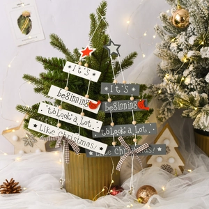 Close-up of wooden Christmas tree hanging signs with red bird and festive bells decor