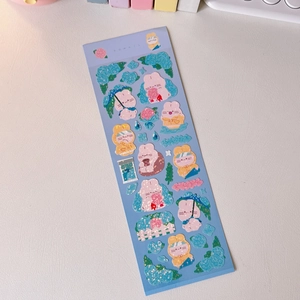 Close-up of cute cartoon rabbit stickers with blue hydrangea floral motifs for journaling