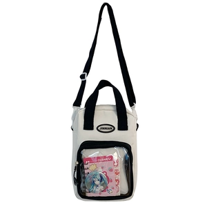 Detail of white canvas crossbody bag featuring a clear window for anime badges
