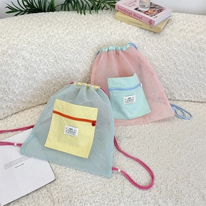 Vue détaillée de sacs à dos en maille à cordon avec couleurs contrastées et petits écussons