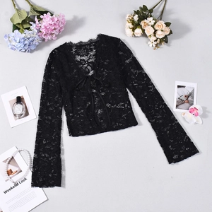 Flat lay of black lace long sleeve cardigan with front tie detail on textured background