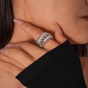 Detailed close-up of multi-layer beaded ring featuring white pearls and silver metal beads