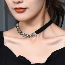 Detail of silver bead chain and black fabric choker worn by a model for a stylish look