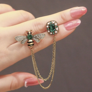 Vintage golden bee brooch with emerald stones and hanging chain for suit jackets