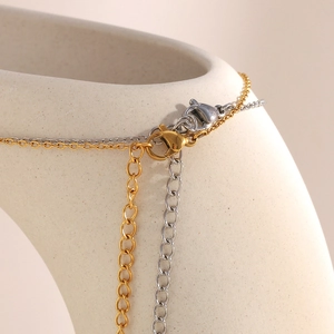 Dettaglio dei fermagli a moschettone e catenelle di estensione in oro e argento