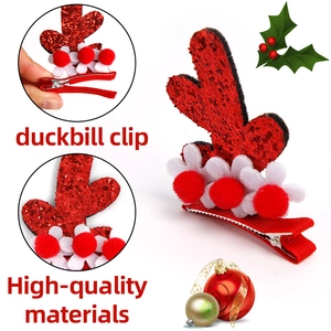 Detail of red sequin reindeer antler hair clip with pom-poms and duckbill clip