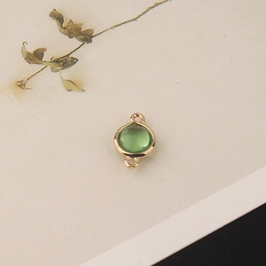 Macro detail of gold-plated green crystal round connector for DIY jewelry making