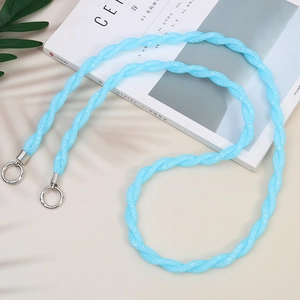 Detail of sky blue braided phone strap with silver metal clasps on a cereal magazine