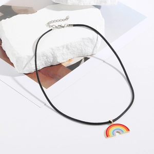 Detail of rainbow heart pendant necklace with gold edges on white stone display