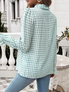 Back view of a green and white plaid shirt with ruffle high collar and bubble sleeves