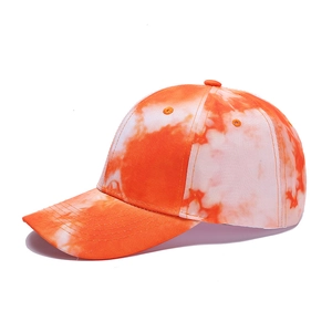 Detail of tie-dye baseball cap in vibrant orange and white with stitched curved brim