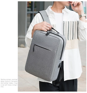 Close-up of gray minimalist backpack with integrated USB charging port on the side