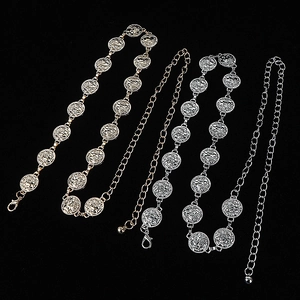 Detailed view of bohemian metal chain belts in gold and silver finish with round patterns